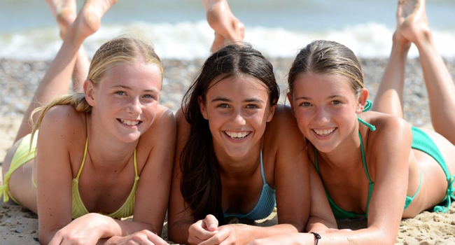 Studentesse sulla spiaggia a Exmouth durante un soggiorno linguistico LISA! sdraiate sulla sabbia godono del sole e del mare