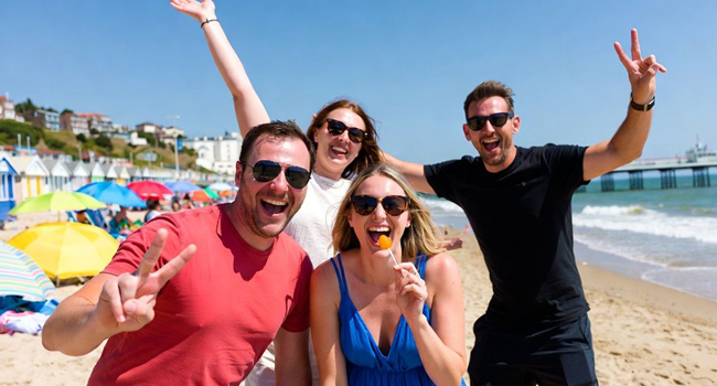 Partecipanti adulti che si divertono sulla spiaggia di Bournemouth durante un soggiorno linguistico LISA! in Inghilterra