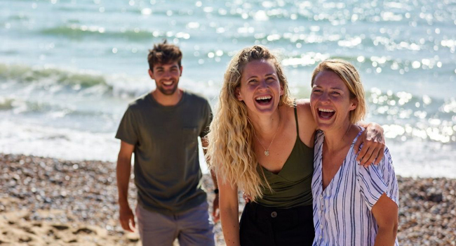 Soggiorni linguistici per adulti in Inghilterra Brighton con LISA! – spiaggia, divertimento ed esperienze indimenticabili Partecipanti adulti che ridono sulla spiaggia di Brighton durante un soggiorno linguistico LISA! in Inghilterra