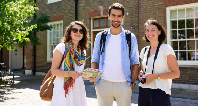  Adulti partecipanti a un soggiorno linguistico LISA! a Cambridge City Inghilterra con una mappa esplorano la zona insieme
