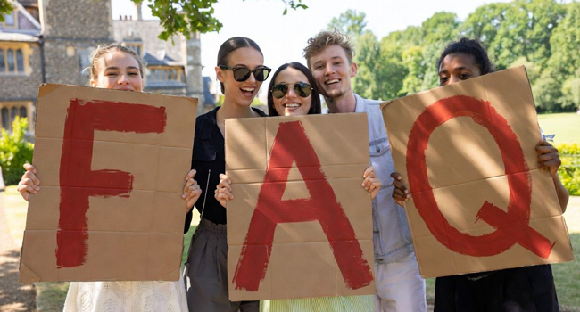 Adulti partecipanti a un soggiorno linguistico LISA! a Cambridge City Inghilterra tengono lettere FAQ in un parco