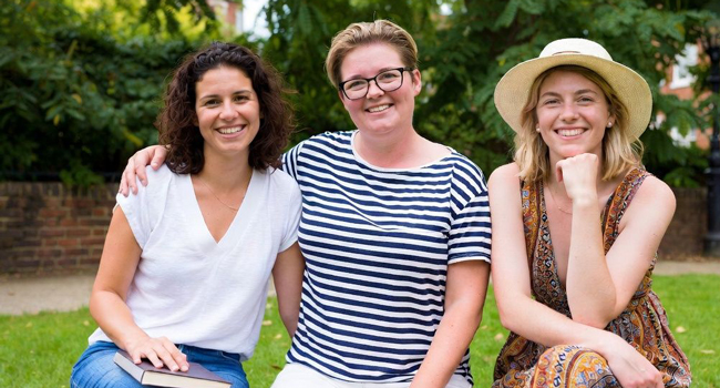 Partecipanti adulte di un soggiorno linguistico LISA! a Cambridge City Inghilterra sedute in un parco godono del tempo insieme