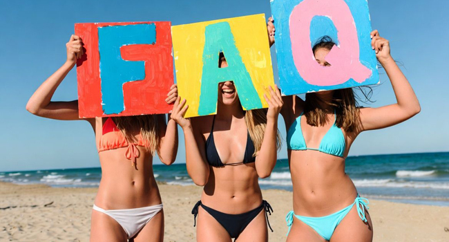 Soggiorni linguistici a Malta per adulti: FAQ e risposte Partecipanti adulte a un soggiorno linguistico a Malta sulla spiaggia con cartelli per domande frequenti e risposte