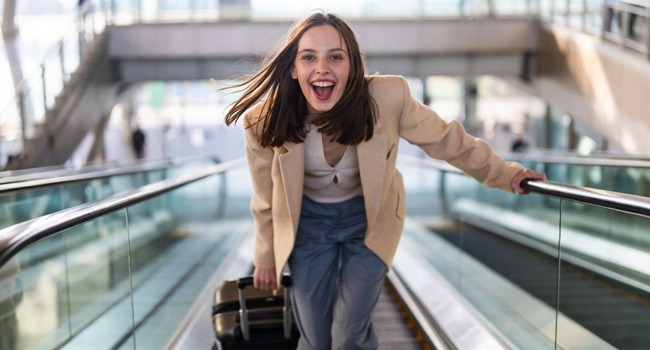 Giovane con valigia in aeroporto durante un congedo formativo LISA! entusiasta di partire per Québec per imparare il francese
