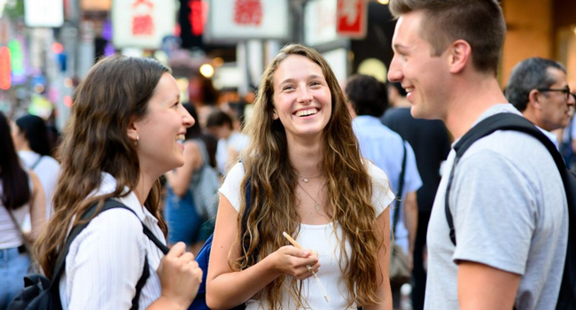 Congedo formativo Osaka Giappone con LISA! – imparare il giapponese, fare nuove amicizie e vivere esperienze indimenticabili Adulti ridono insieme a Osaka durante un congedo formativo LISA! godono della vita urbana internazionale e imparano il giapponese