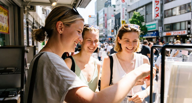 Adulti acquistano street food a Tokyo durante un soggiorno linguistico LISA! scoprono specialità locali e cultura
