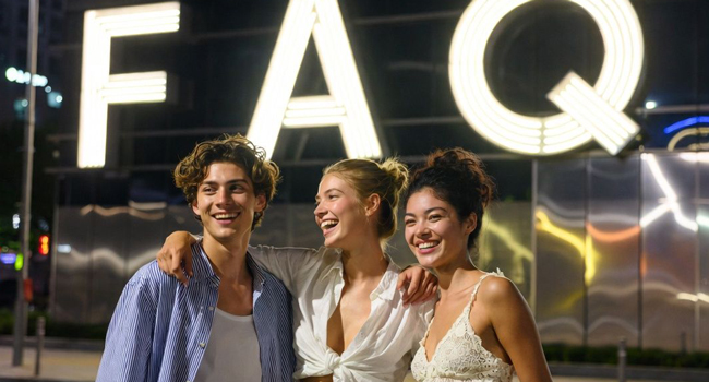 Giovani adulti davanti a un’insegna luminosa FAQ a Seoul di notte durante un soggiorno linguistico LISA! vivono la vita notturna