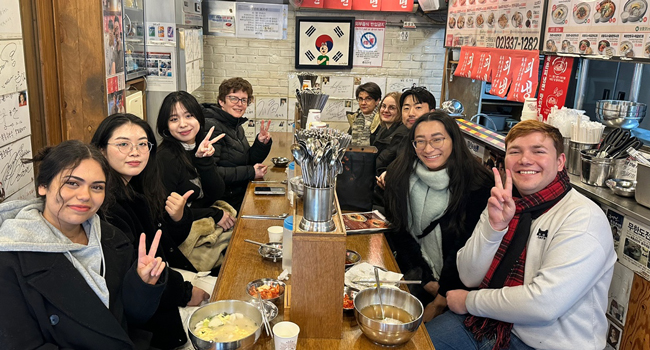 Adulti mangiano insieme in un ristorante a Seoul durante un soggiorno linguistico LISA! gustano la cucina coreana in gruppo