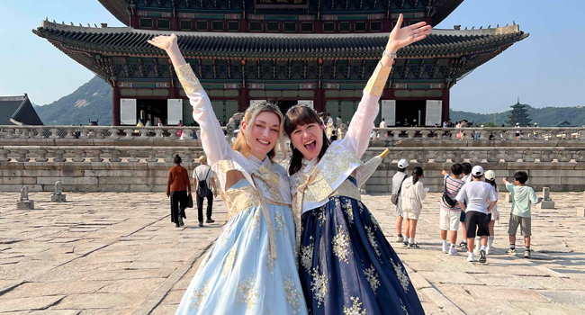 Adulti in abiti tradizionali coreani davanti a un tempio a Seoul durante un soggiorno linguistico LISA! vivono la cultura
