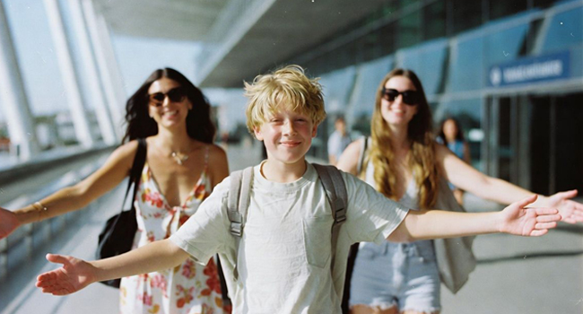 Arrivo ragazzo all’aeroporto con la sua famiglia Arrivo ragazzo all’aeroporto di Bangkok con la sua famiglia