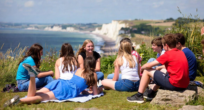 Soggiorni linguistici in Inghilterra Eastbourne con LISA! – tempo libero, natura e costa spettacolare Gruppo di studenti a Eastbourne Inghilterra durante un soggiorno linguistico LISA! seduto sulle scogliere con vista mare