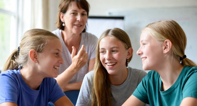 Lezione di inglese per studentesse a Eastbourne Inghilterra con insegnante in aula durante un soggiorno linguistico LISA!
