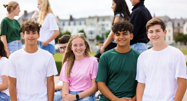  Gruppo di studenti a Exmouth durante un soggiorno linguistico LISA! seduti insieme all’aperto godono del supporto e della comunità