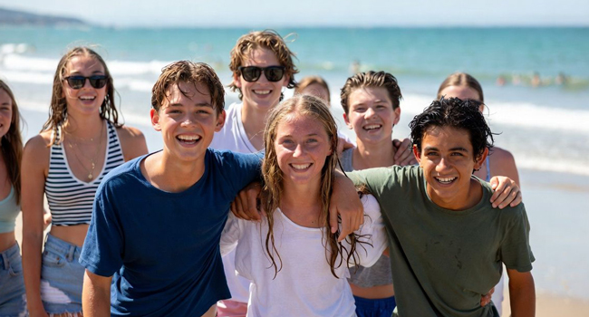  Gruppo di studenti sulla spiaggia a Exmouth durante un soggiorno linguistico LISA! si gode il tempo libero, il mare e le esperienze insieme