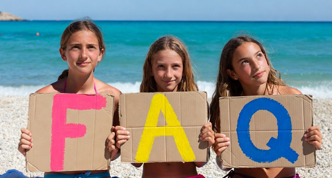 FAQ soggiorni linguistici LISA! – risposte su Jersey per studenti Studentesse a Jersey tengono lettere FAQ sulla spiaggia durante un soggiorno linguistico LISA! con il mare sullo sfondo
