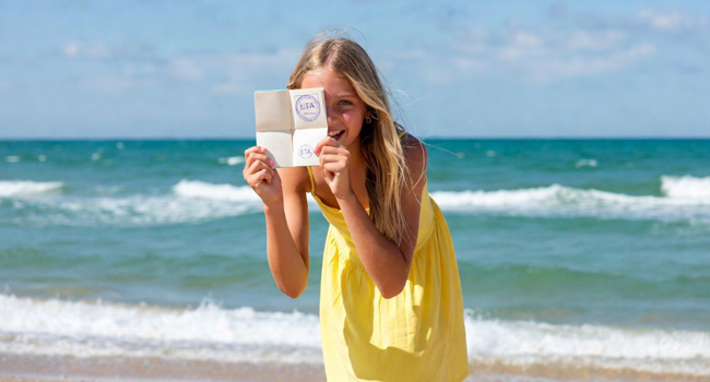 Soggiorni linguistici a Portsmouth con LISA! – ingresso, visto e informazioni importanti per studenti Studentessa sulla spiaggia a Portsmouth durante un soggiorno linguistico LISA! mostra documento di ingresso per l’Inghilterra