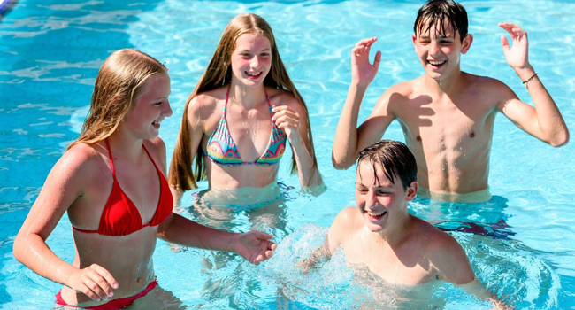 Soggiorni linguistici per studenti a Malta con LISA! – divertimento e tempo libero in piscina Quattro studenti che si divertono in piscina durante un soggiorno linguistico LISA! per studenti a Malta