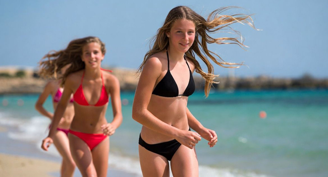 Soggiorni linguistici per studenti a Malta con LISA! – ragazze sulla spiaggia in estate Due ragazze che corrono sulla spiaggia a Malta durante un soggiorno linguistico LISA! per studenti
