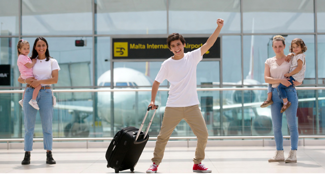 Soggiorni linguistici di inglese a Malta per studenti con arrivo tramite l’aeroporto Studenti di un soggiorno linguistico di inglese a Malta durante l’arrivo in aeroporto con valigia e scena di accoglienza