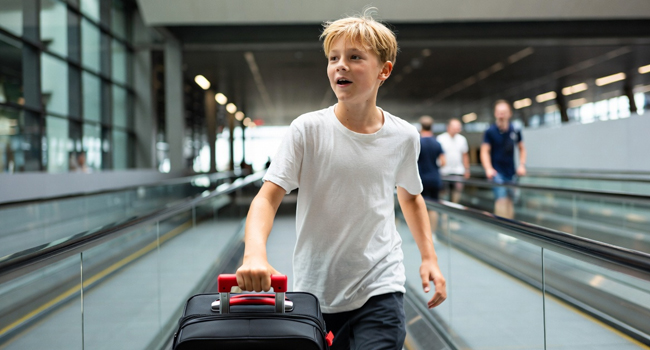 Arrivo a un soggiorno linguistico LISA! per studenti a Málaga, Spagna – un ragazzo su un tapis roulant in aeroporto. Un ragazzo che arriva su un tapis roulant in aeroporto per un soggiorno linguistico per studenti a Málaga simboleggia l’arrivo a un soggiorno linguistico LISA! per studenti a Málaga, Spagna.