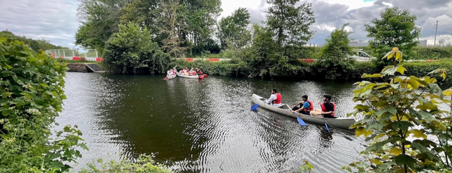 Ausflug mit dem Boot an der LISA! Sprachschule in Exeter Eine Flusslandschaft in Devon mit zwei Paddelbooten und hohen Bäumen