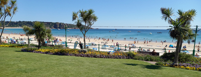 Blick auf den belebten Strand im Sommer mit Badegästen bei einer Sprachreise in Jersey