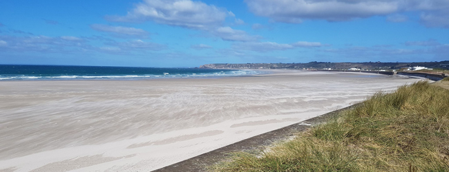 Breiter weißer Sandstrand an der Insel Jersey in England im Sommer