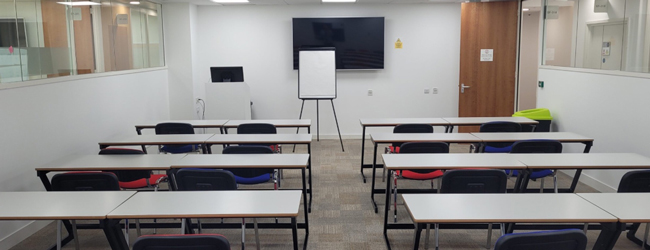 Modernes Klassenzimmer der Sprachschule in Leeds Leeres Klassenzimmer mit Tischen, Stühlen und einem Whiteboard für den Unterricht während der LISA! Sprachreise in Leeds