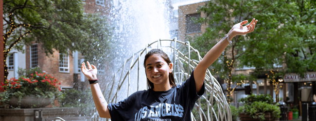 Freude an einem Brunnen in Toronto Downtown Ein Mädchen reckt die Arme nach oben bei einer LISA! Sprachreise in Toronto