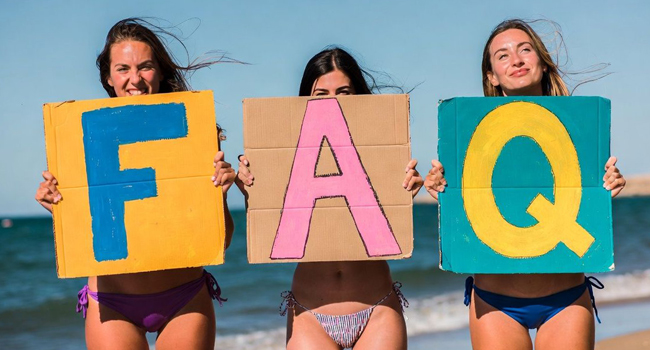 FAQ Fragen und Antworten Sprachreisen Malta St. Julilans mit LISA! Sprachreisen 3 Frauen mit Pappschildern am Strand Malta mit Aufschrift FAQ