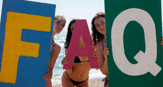 FAQ zu Sprachreisen in Antibes | LISA! Sprachreisen Frauen am Strand mit großen FAQ-Buchstaben für Fragen und Antworten zu Sprachreisen in Antibes mit LISA! Sprachreisen