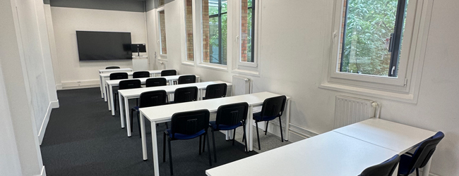 Klassenraum für die Französisch-Sprachkurse in Paris Leeres Klassenzimmer mit blauen Stühlen und Blick ins Grüne in der LISA! Sprachschule in Paris