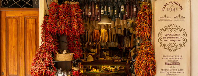 Offenes Geschäft mit Wurstwaren und roten Pimentos, die von der Decke hängen auf Mallorca