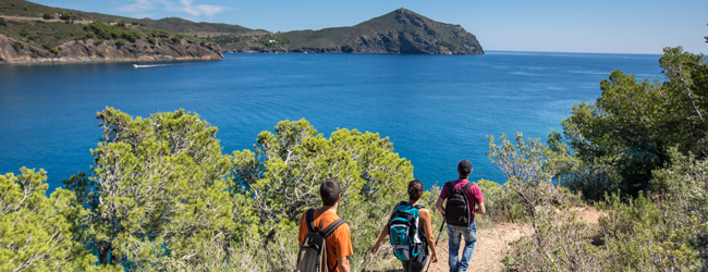 Drei Personen wandern entlang der Küste mit Blick auf das Meer bei einer Sprachreise auf Mallorca