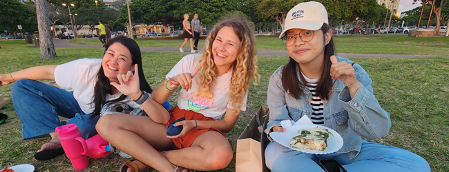 Picknick im Park für drei Mädchen bei einer Sprachreise für Familien auf Hawaii Drei Mädchen sitzen im Park und essen bei einer LISA! Sprachreise für Familien in Honolulu