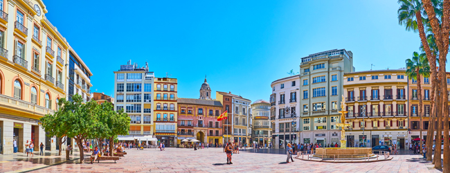 Der Hauptplatz von Málaga mit Brunnen, Bäumen und Geschäften