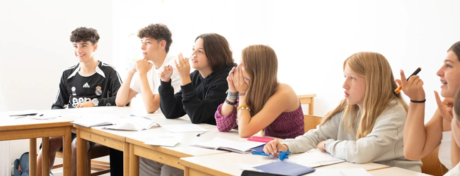 Schüler sitzen in einem Klassenraum und hören zu bei einem Englisch-Sprachkurs