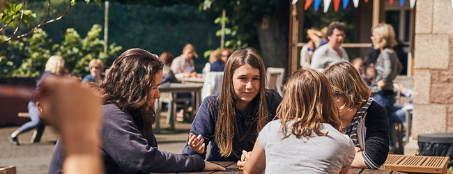 Mädchen sitzen in der Pause auf dem Hof der LISA! Sprachschule in Jersey