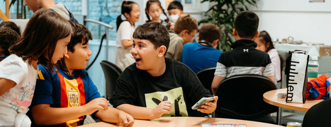 Kinder sitzen an einem Tisch und spielen Karten bei einer LISA! Familiensprachreise