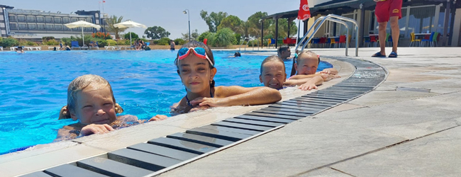 Badespass im Swimming Pool bei einer Sprachreise für Schüler in Famagusta Mädchen schauen am Rand eines Swimmingpools heraus bei einer LISA! Schülersprachreise in Famagusta