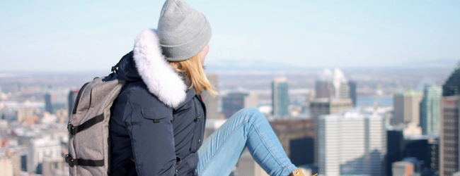 Blick über die Skyline von Montreal bei einer LISA! Sprachreise Eine Frau mit Jacke und Mütze blickt auf die Skyline von Montreal, Kanada